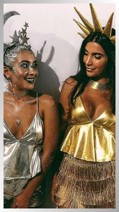 two women dressed in costumes standing next to each other with their faces painted gold and silver