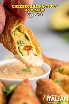 a person dipping some food into a small white bowl filled with dip and cheesecake factory avocado egg rolls