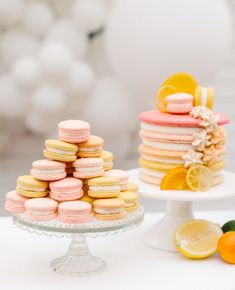 there are many macaroons and oranges on the cake platter with lemon slices