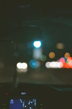 the dashboard of a car at night with blurry lights in the backgroud