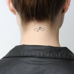 a woman's back neck with a small tattoo on the left side of her neck