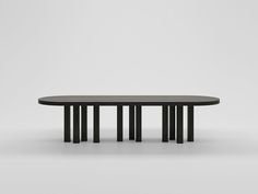 an oval table with four black columns on the top and bottom, in front of a white background