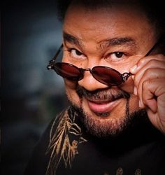 a close up of a person with sunglasses on his head and a moustache