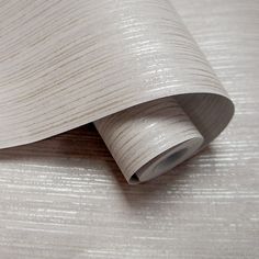 the wall paper is white and beige with stripes on it's sides, as well as a roll of tape