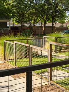 a fenced in area with grass and trees