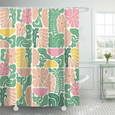 a bathroom with a shower curtain that has flowers and leaves on it, along with a tub