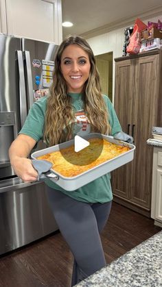 a woman holding a pan filled with food