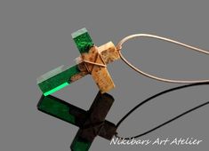 Emerald green cross necklace. This wood and green resin cross necklace is one of a kind and it has been handcrafted from a carefully choosen piece of wood and has been combined with emerald green epoxy resin.  CROSS GALLERY : https://www.etsy.com/shop/NikibarsNatureArt?section_id=16787849&ref=shopsection_leftnav_5  Cross height - 1 15/16 inches (49 mm) The length of the cord is about 30 inches (77 cm), but it can be regulated by the movable knot. Materials utilised: burl wood, emerald green resin Production method  100% hand made by natural materials. BUYING FROM NikibarsNatureArt It's worth knowing that when you buy from my store, 5 % of the amount goes for help of orphanage of the Bulgarian priest Father Ivan or other children in need. ADDITIONAL POLICIES AND FAQs I am always happy to di Green Cross Pendant Necklace As Gift, Green Cross Necklace For Gift, Handmade Green Cross Jewelry, Green Cross Necklace, Emerald Cross Pendant, Unique Green Resin Necklaces, Emerald Cross, Resin Cross, Boho Cross