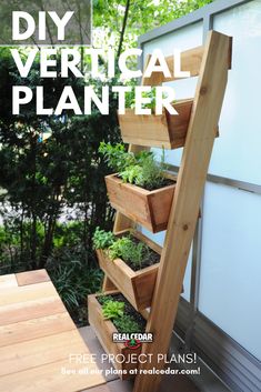 a wooden planter filled with plants on top of a wooden floor next to a tree