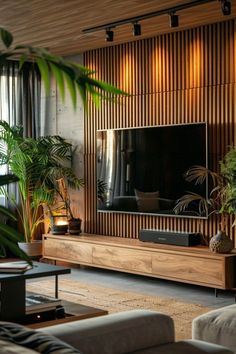 a living room filled with lots of furniture and plants in front of a flat screen tv