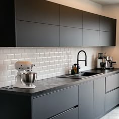 a kitchen counter with a mixer on top of it next to a sink and oven