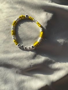 a yellow and white beaded bracelet with the word peep on it's side