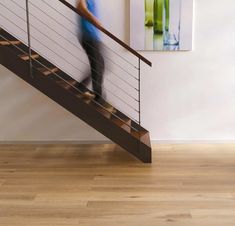 a person walking up the stairs in front of a painting on the wall behind them