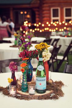 there are many vases with flowers in them on the table at this wedding reception