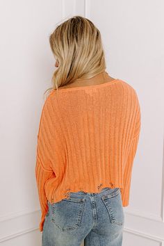 - Perfect for your next latte run, this trendy new sweater will keep you looking stylish! - Lightweight, ribbed knit material in an orange hue - Wide, boat cut neckline with rolled detail - Long, loose sleeves - Exposed seam accents - Relaxed silhouette that ends in a distressed cropped hemline Measurements S : Bust 48", Length 17.5", Sleeve Length 17", Waist 48". M : Bust 50", Length 18.5", Sleeve Length 18", Waist 50". L : Bust 52", Length 19", Sleeve Length 18", Waist 52". Orange Long Sleeve Stretch Sweater, Orange Stretch Long Sleeve Sweater, Trendy Orange Soft Knit Sweater, Trendy Orange Crew Neck Sweater, Orange Soft Knit Sweater For Spring, Orange Ribbed Crew Neck Top, Casual Orange Ribbed Sweater, Orange Textured Knit Crew Neck Sweater, Spring Textured Knit Orange Top