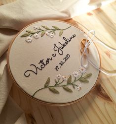 the embroidered wedding ring sits on top of a wooden table