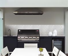 a kitchen with an oven, stove and dining room table in the middle of it