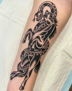 a man's arm with a black and white tattoo design on it, including a horse