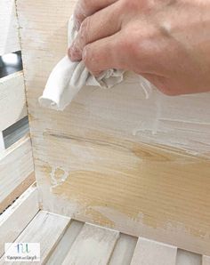 a person wiping down some wood with a cloth