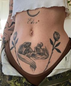 a woman's stomach with tattoos on it