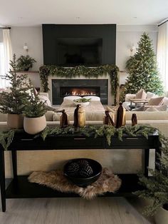 a living room filled with furniture and a fire place covered in greenery next to a fireplace