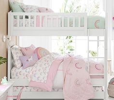 a white bunk bed with pink sheets and pillows on it in a girls'bedroom