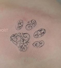 a tattoo on the back of a man's shoulder with four leaves and swirls