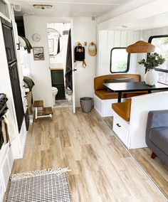 the interior of an rv with wood flooring and white walls is featured in this post