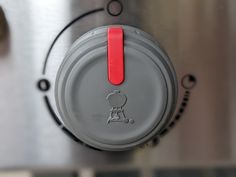 a close up view of the top of a toaster with red buttons on it