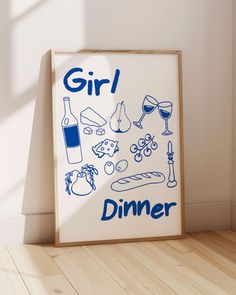 a framed poster with the words girl dinner on it next to a wooden floor in front of a white wall