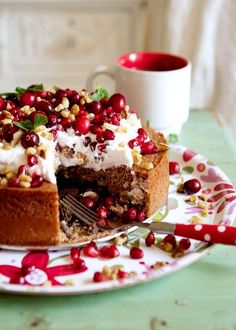 a cake with white frosting and pomegranates on it sitting on a plate