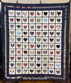 a quilt with hearts on it is hanging from a rack in front of a wall