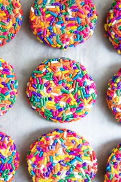 sprinkle covered cookies and lollipops on a tray