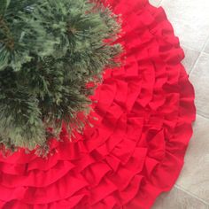 a pine tree with red ruffles on the bottom and white tile flooring