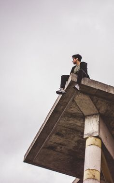 a man sitting on top of a tall building