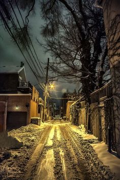 a snowy street at night with no cars on it