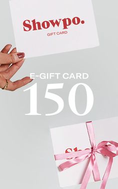 a woman's hand holding a gift card with pink ribbon