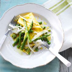 a white plate topped with asparagus and cheese