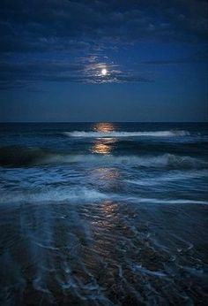 the moon is setting over the ocean waves