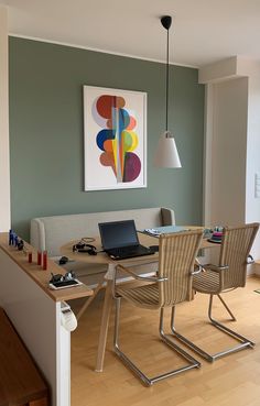 a laptop computer sitting on top of a wooden table next to a white couch in a living room