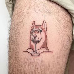 a man with a dog tattoo on his thigh holding a wine glass in it's mouth