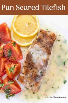 a white plate topped with fish and tomatoes