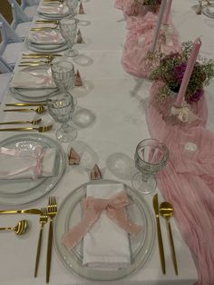 the table is set with pink and gold place settings