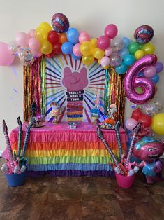 a table with balloons, streamers and decorations for a kids's birthday party