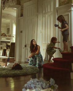 two women and a child are cleaning the stairs in a house with carpet on the floor