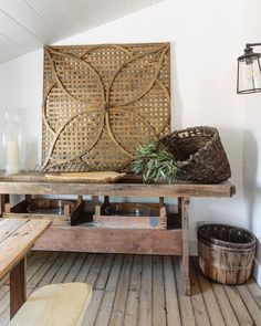 a wooden table sitting on top of a wooden floor next to a basket and candle