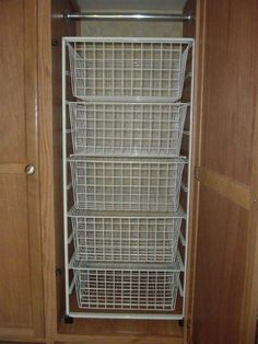 the closet door is open and there are wire baskets in it on the bottom shelf