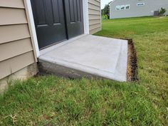 a concrete step is being installed to the side of a house