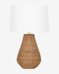 a wicker lamp with a white shade on it