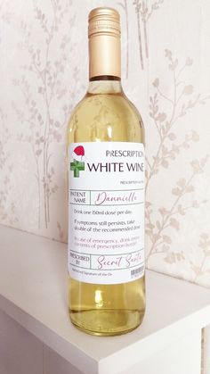 a bottle of white wine sitting on top of a table next to a wallpaper